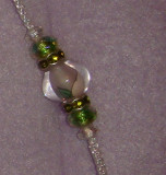 Glass bead with green rondell accents