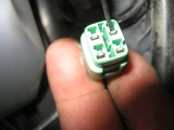 Release the pin by lifting the tab above it with a small jewlers screwdriver, then pull the wire out the backside