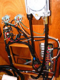 Rear of helm; gauges and bilge pump controls to left; major switch panel lower right behind steering cable.