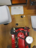 Bilge access hatch in gray plastic; battery box hatch lid in wood, with black latches.