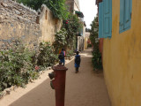Children walking down a path.  Many of the colonial houses on Gore Island are painted in pastel colors.