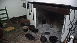 Cooking utensils and pots in front of the fireplace in the kitchen.