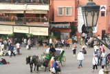 A view looking down at Place Djemaa El-Fna below with a street lamp in the foreground.