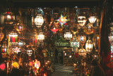 A Moroccan lamp shop with illuminated lamps off of the square.