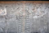 Symbolic scene depicting King Ashurnasirpal dressed in ritual robes in front of a Sacred Tree making a gesture of worship to god