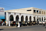 A line of tuk-tuks in front of an arcade, Port Sudan
