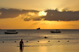 A bather wades in the shallow water at sunset, Mauritius