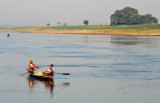 Fisherman and boy paddling up river