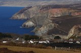 The rooftops of St Agnes & mineral-rich cliffs beyond