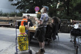 Very Strange Man with Large Paper Mache Chicken on Wheels Selling Dead Flowers to Diners