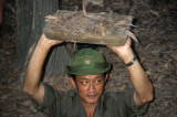 Cu Chi. Soldier showing a narrow entrance of the Vietcong tunnels