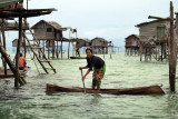 Pulau Bodgaya: Sea gypsy girl paddling her boat between the houses on stilts in the sea