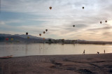 Kids playing at sunset as balloons float by