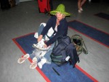 Judy on the Toronto Airport floor, taking the sand out of her shoes!!
