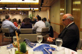 Sylvester Lukis speaking and Eli Mizrahi in the foreground at the Dick Judy Celebration of Life luncheon