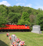 NS 387 is slowing to make a pickup at Yuma, passing a small grave yard on the outskirts of town
