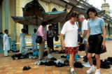 Tourists remove their shoes at the Cao Dai temple