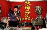 A huckster selling snake oil, quite literally, at a Chinatown festival