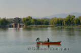 Couple rowing past the Willow Bridge on South Kunming Lake Summer Palace Beijing