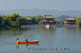 Couple rowing past the Pavilion of Bright Scenery with Jade Peak Pagoda on Kunming Lake Summer Palace Beijing