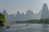 Tour boat rafts on the Li river Guangxi China with fingerlike karst mountain peaks in the haze