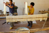 Husband and wife hanging wheat noodles in a shop in Fuli near Yangshuo China