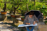 Female student artist drawing in the garden of a farm house in Hongcun village in China