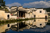 White buildings reflected in the still Half moon pond in the ancient village of Hongcun China