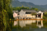 Willow trees on the Longxi river with ancient bridge and Hui houses in Chengkan China