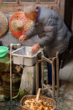 Old Chinese man washing yams in an ancient Hui house in Chengkan village China