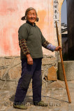 Old Chinese woman with staff walking in ancient village of Chengkan Huangshan China