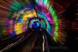 Streaking multicolored lights and rails of the Bund Sightseeing Tunnel under the Huangpu River Shanghai China