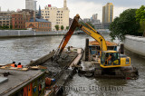 Excavator and barge dredging the Wusong river at the Waibaidu bridge Shanghai China