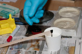 Han tilsetter litt fargepigment for  f mrkegr farge p delen