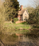 Rural  cottage  reflected  in  pond.