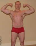 hunk blond bodybuilder strong man lifting weights flexing.jpg