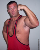 a red singlets gay wrestler flexing arms.jpg