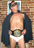 pro wrestler wearing championship belt cape crusader.jpg