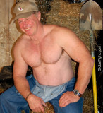 smiling farmer rancher man leaning on hay bales.jpg