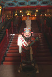 Entrance to a silk factory with an interesting Chinese figure greeting customers at the base of the stairs.