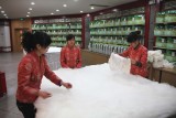 Women with raw silk, which is often used for lining.