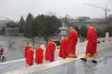Procession of monks leaving the Wild Goose Pagoda in the rain.