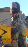A leopard-clad woman on stilts with hoops.