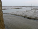 Het wad drooggevallen met vaargeul naar haven Schiermonnikoog