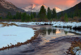 Mountain stream at sunset with snow