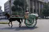 Horse drawn cart with very large wheels in the middle of Lahore