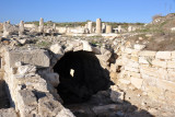 An archway leading to a dark underground chamber of ancient Kourion