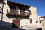 Studry stone house with dark wooden doors and balcony, Omodos