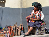 Woman selling wood carvings in front of the Maya Inn
