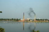 Reflextions of smokestacks in a lake southeast of Dhaka